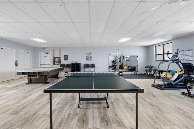 recreation room featuring billiards, a paneled ceiling, and light wood-type flooring