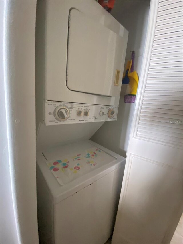 washroom with stacked washing maching and dryer