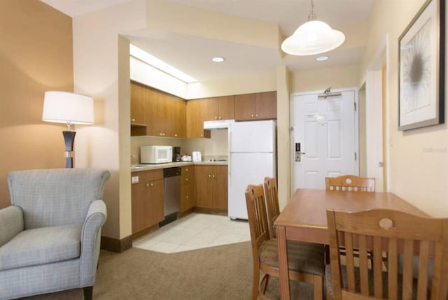 kitchen with pendant lighting, light colored carpet, and white appliances