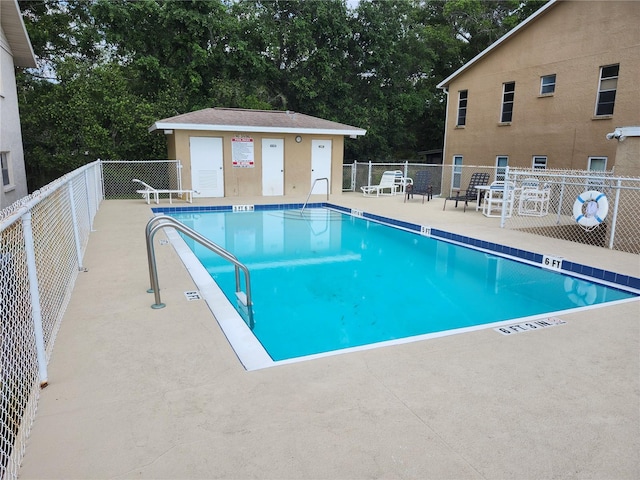 view of pool with a patio and an outdoor structure