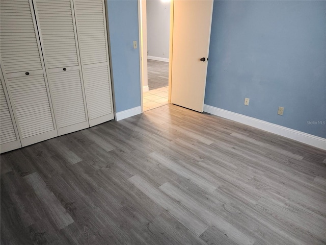 unfurnished bedroom with light hardwood / wood-style flooring and a closet