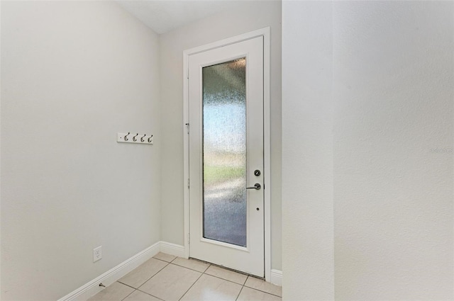 doorway to outside featuring light tile flooring