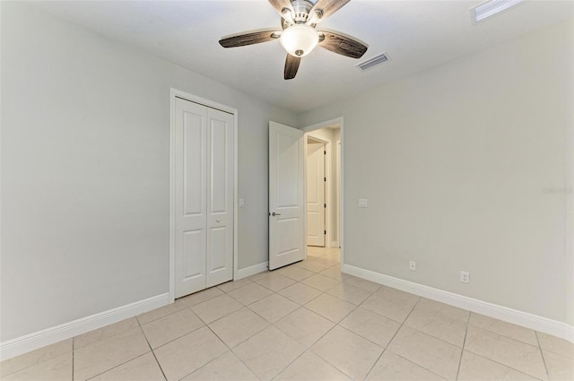 unfurnished bedroom with ceiling fan, a closet, and light tile floors