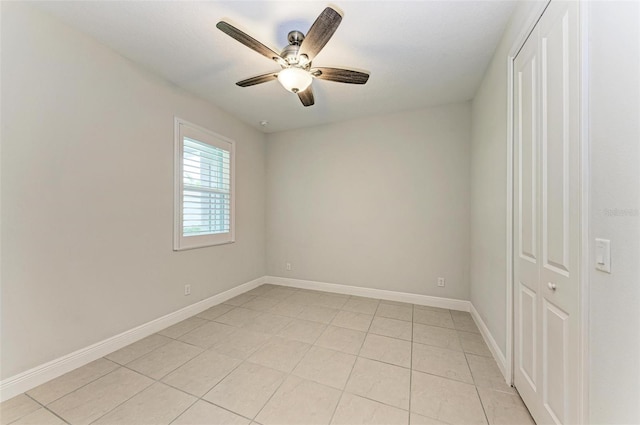 empty room with ceiling fan and light tile floors