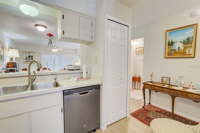 kitchen featuring white cabinets, sink, light hardwood / wood-style floors, and stainless steel dishwasher