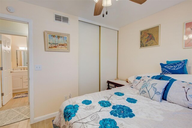 bedroom featuring a closet, ceiling fan, connected bathroom, sink, and light hardwood / wood-style flooring