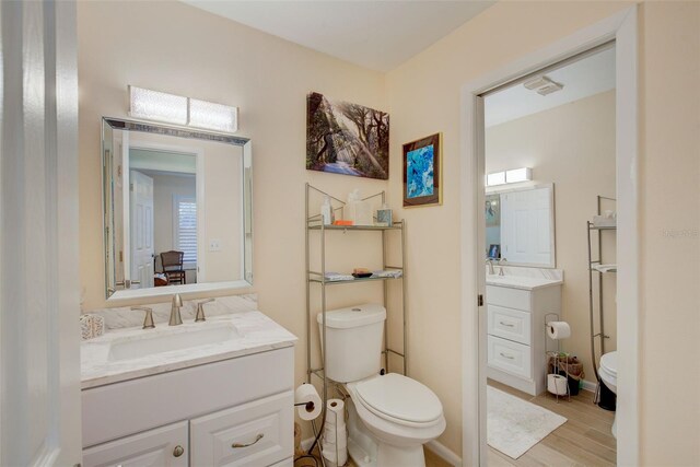 bathroom featuring hardwood / wood-style flooring, vanity, and toilet