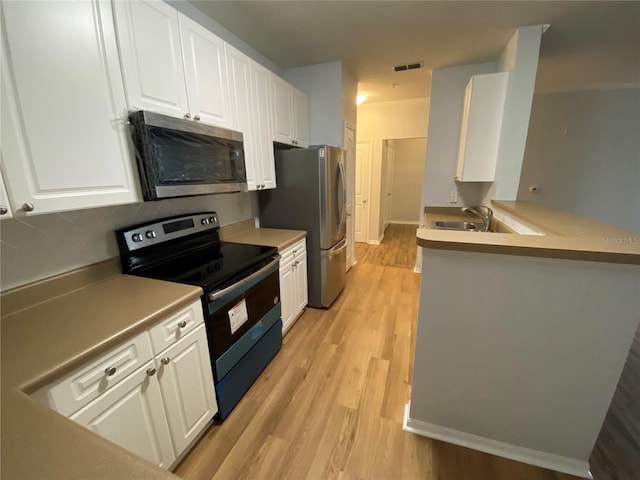 kitchen featuring electric range oven, white cabinets, backsplash, sink, and light hardwood / wood-style floors