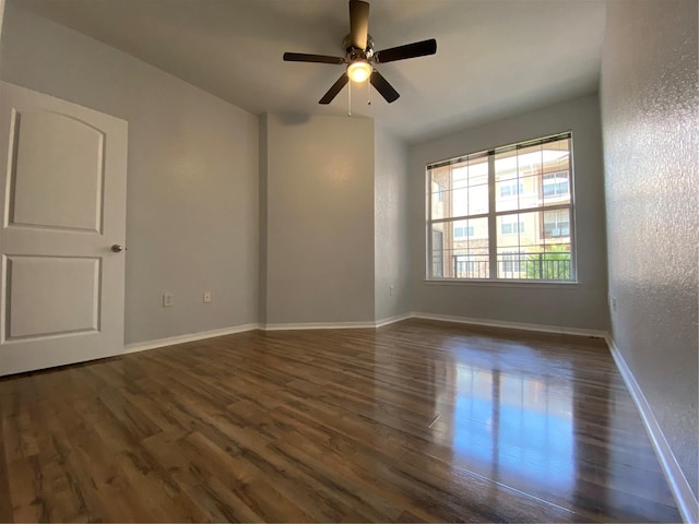 empty room featuring dark wood-type flooring and ceiling fan