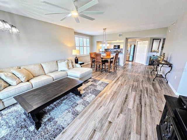 living room with wood-type flooring and ceiling fan