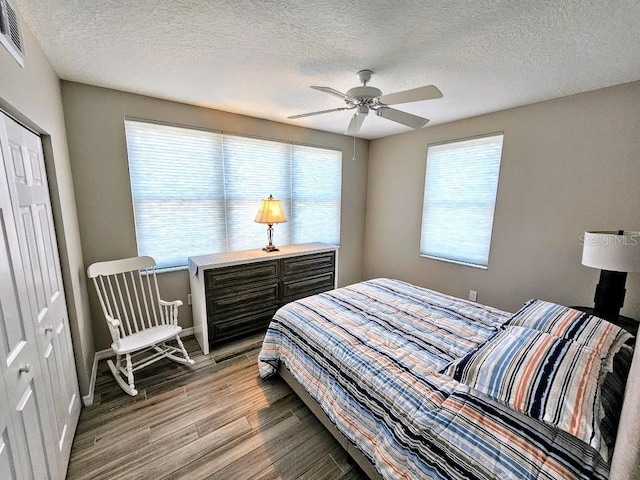 bedroom with a textured ceiling, a closet, ceiling fan, and hardwood / wood-style floors