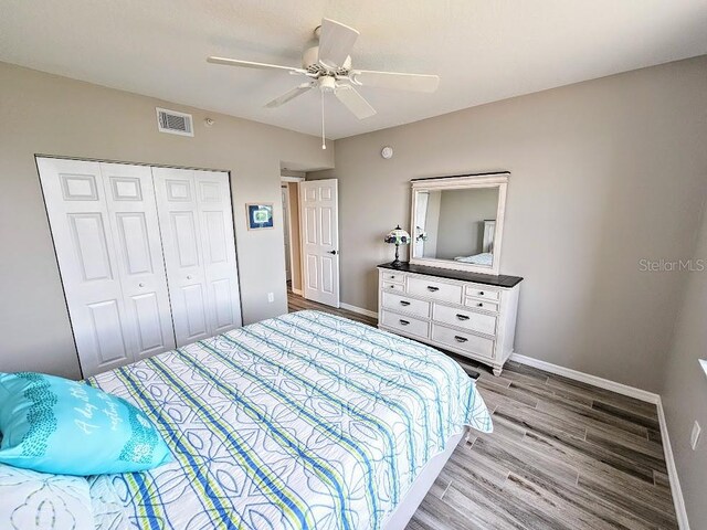 bedroom with light wood-type flooring, a closet, and ceiling fan