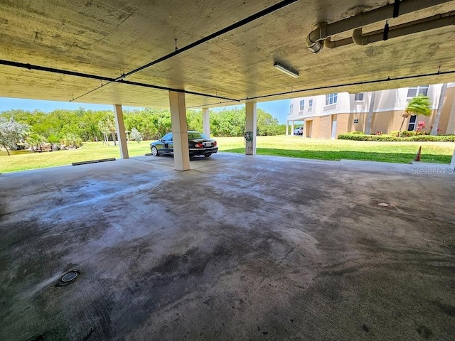 garage featuring a lawn and a carport