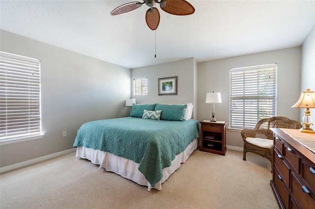 carpeted bedroom featuring a textured ceiling, ceiling fan, and multiple windows