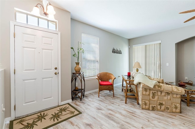 foyer entrance featuring an inviting chandelier and light hardwood / wood-style flooring