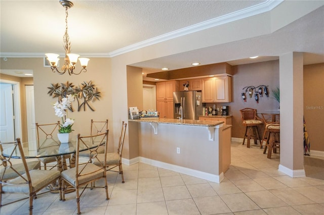 kitchen with stainless steel refrigerator with ice dispenser, a kitchen breakfast bar, and crown molding