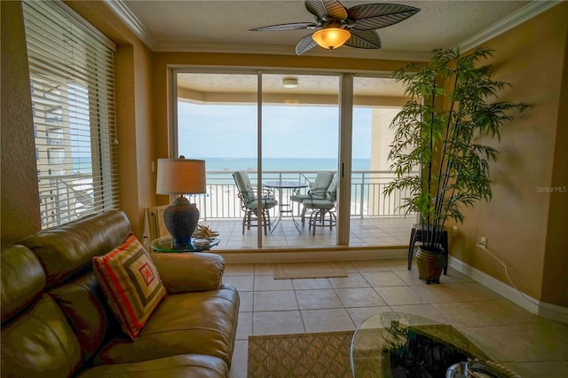 tiled living room with ceiling fan, ornamental molding, a textured ceiling, and a water view