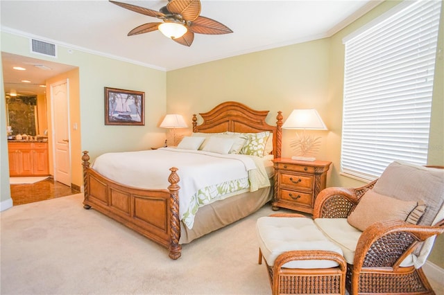 carpeted bedroom featuring ceiling fan, crown molding, and ensuite bathroom