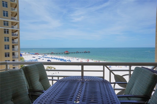 balcony featuring a beach view and a water view