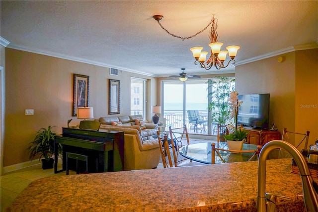 dining area featuring tile flooring, ornamental molding, a textured ceiling, and ceiling fan with notable chandelier