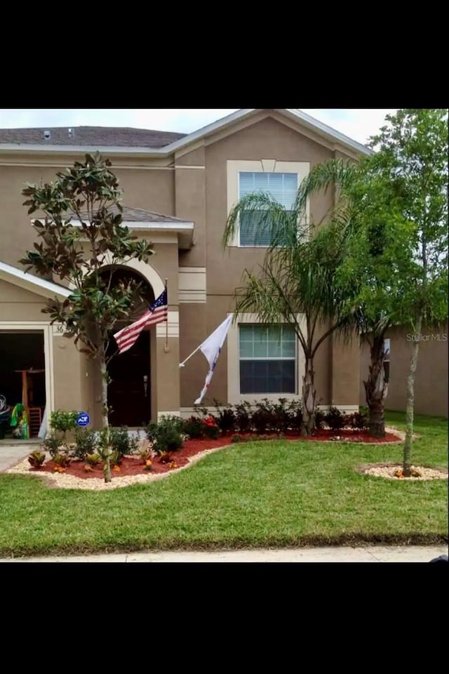 view of front of property featuring a garage and a front lawn