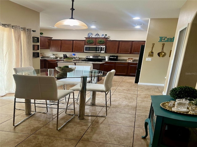 kitchen featuring pendant lighting, black fridge, and light tile patterned floors