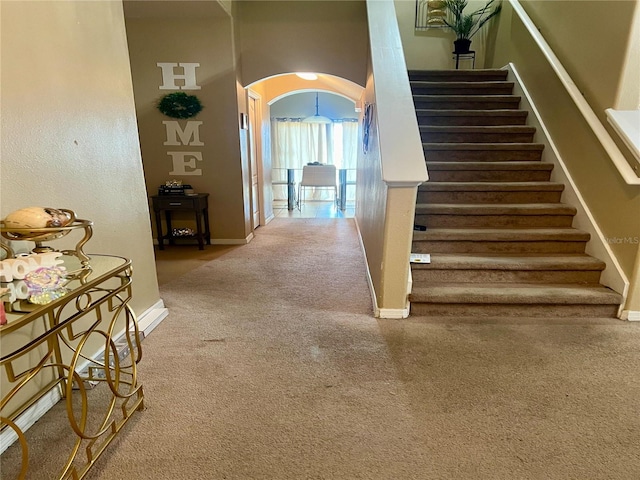 stairs with carpet floors and a towering ceiling