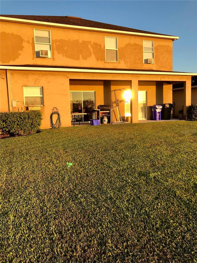 rear view of house featuring a lawn