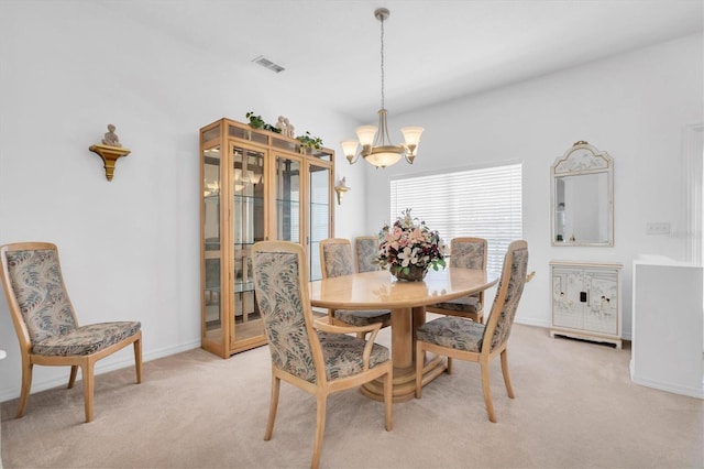 carpeted dining space featuring a chandelier