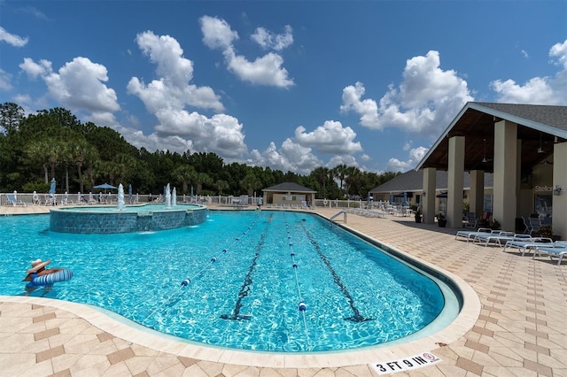 view of swimming pool with pool water feature and a patio area