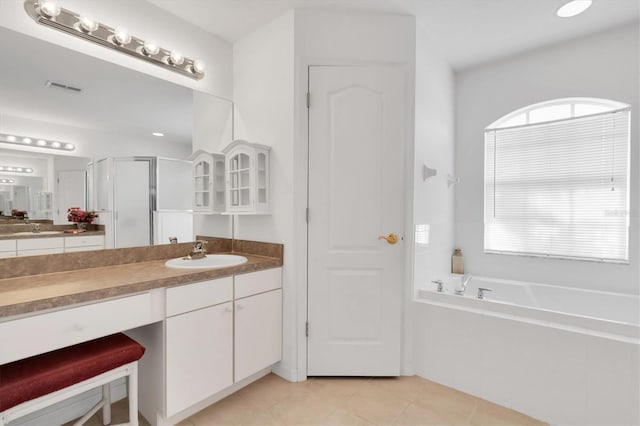 bathroom with plus walk in shower, vanity, and tile patterned flooring