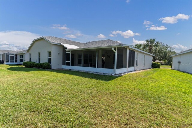 rear view of property featuring a sunroom and a yard