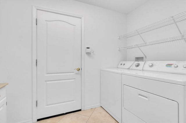 laundry area featuring washer and dryer and light tile patterned flooring