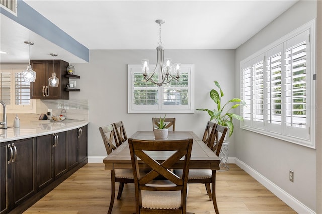 dining area featuring light wood-type flooring, plenty of natural light, and visible vents