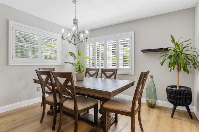 dining room featuring a chandelier, light wood-style flooring, and baseboards