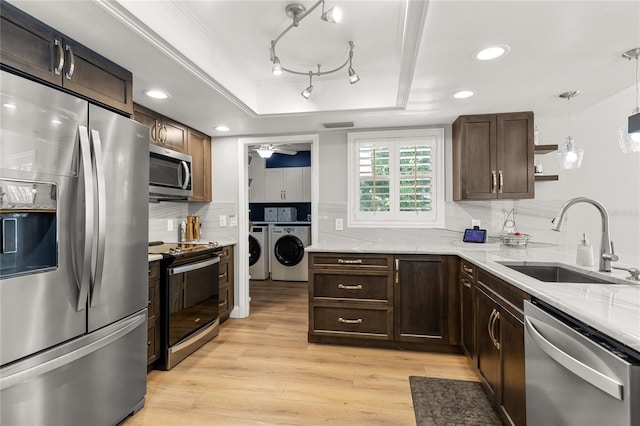 kitchen with a tray ceiling, pendant lighting, open shelves, stainless steel appliances, and a sink