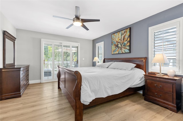 bedroom with baseboards, light wood-style floors, a ceiling fan, and access to exterior