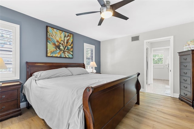 bedroom with baseboards, visible vents, and light wood finished floors