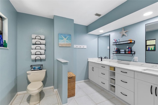 full bath featuring double vanity, visible vents, toilet, a sink, and tile patterned floors