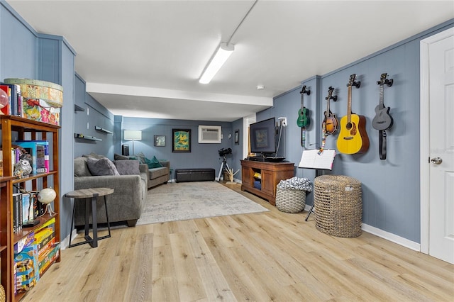 living room with light wood-style floors and a wall unit AC