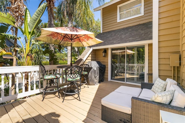 wooden terrace with an outdoor living space and grilling area