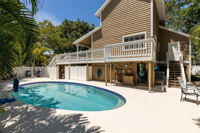 view of swimming pool featuring a deck, fence, stairs, a fenced in pool, and a patio area