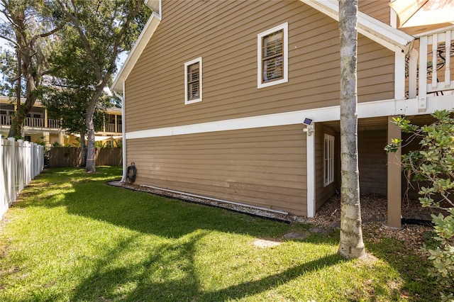 view of side of home featuring a fenced backyard and a lawn