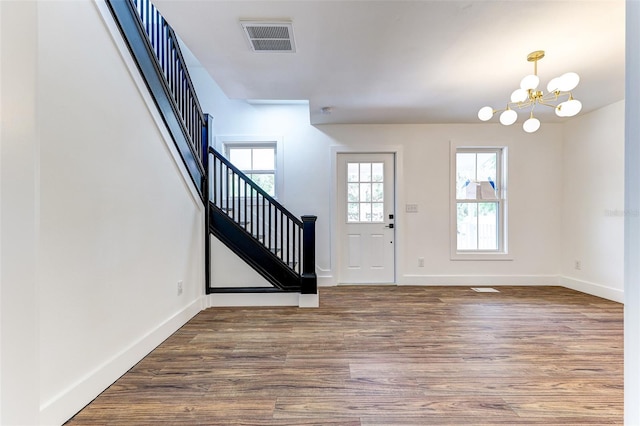 entryway with a notable chandelier, wood-type flooring, and a wealth of natural light