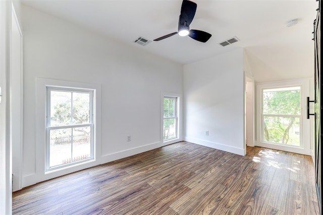 spare room featuring a high ceiling, wood-type flooring, and ceiling fan