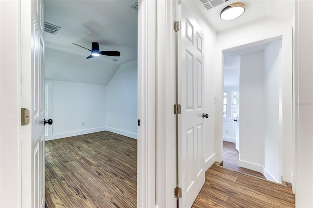 corridor with dark hardwood / wood-style flooring and lofted ceiling