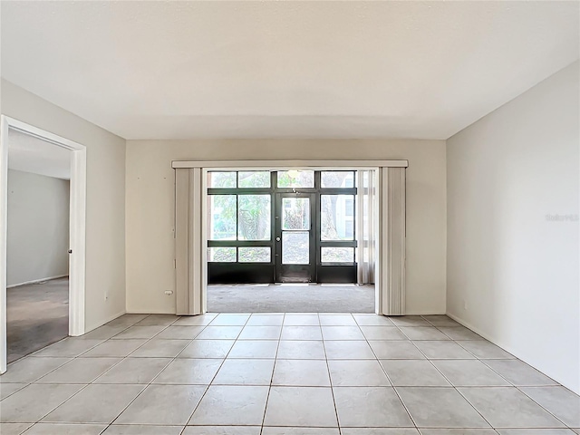 tiled empty room featuring french doors