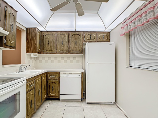 kitchen featuring sink, white appliances, decorative backsplash, and light tile patterned floors