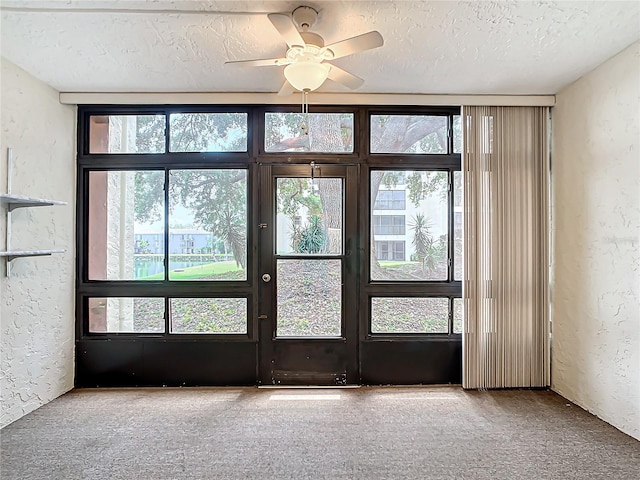 entryway featuring a textured ceiling, carpet flooring, and ceiling fan