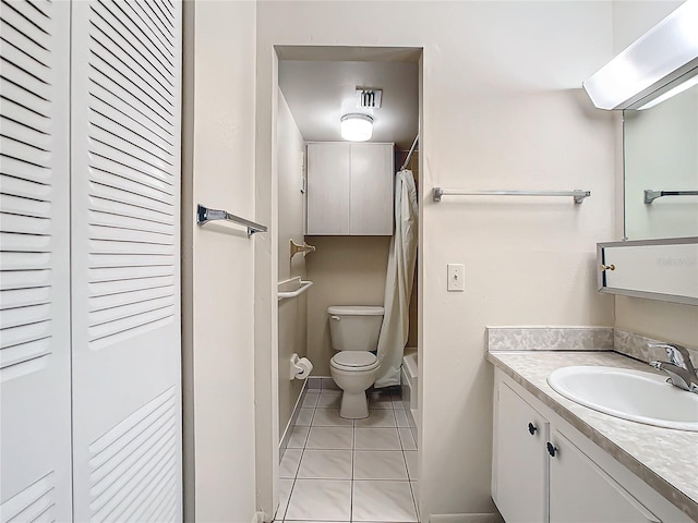 bathroom with toilet, vanity, and tile patterned flooring